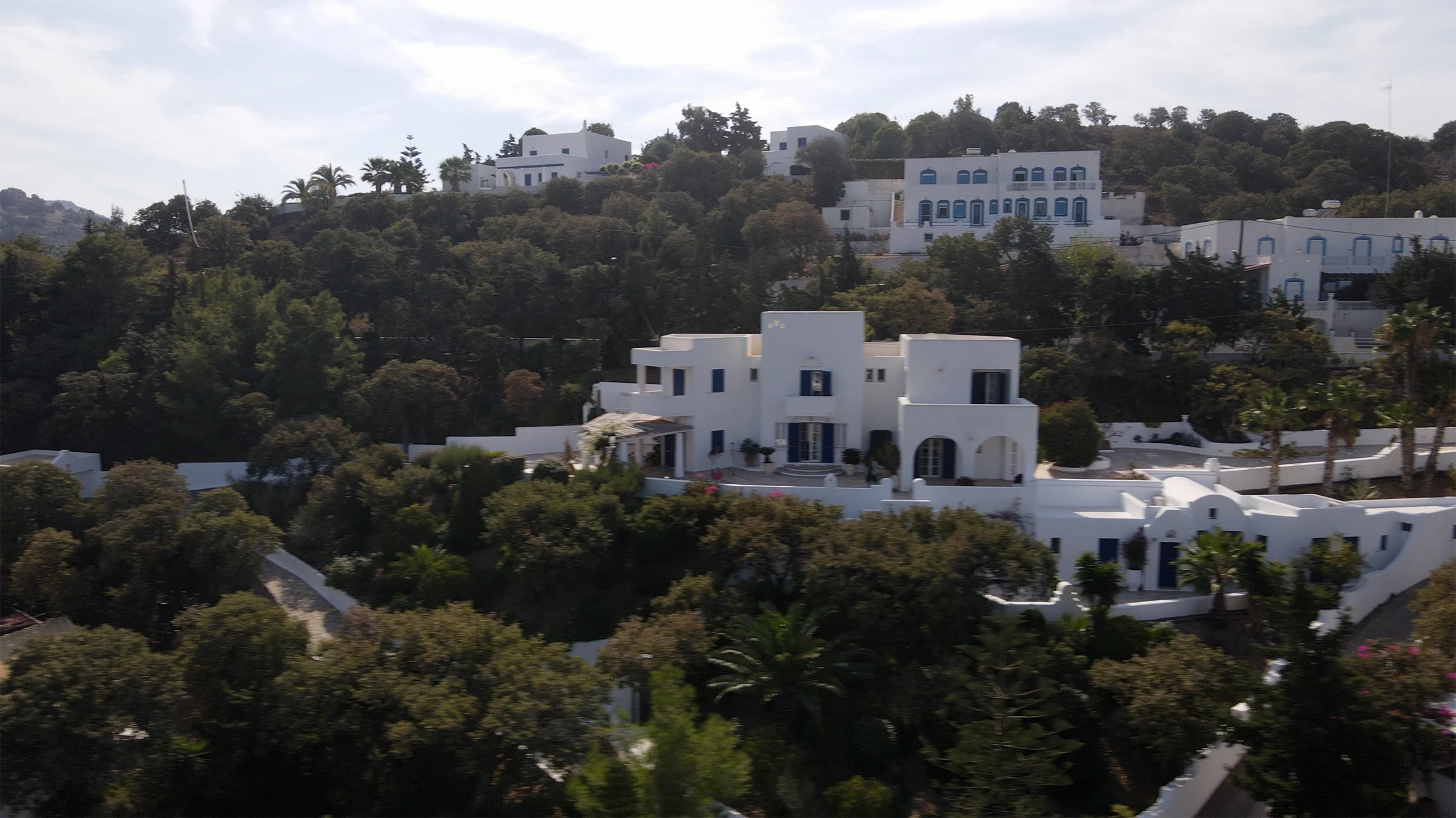 White buildings amidst lush greenery.